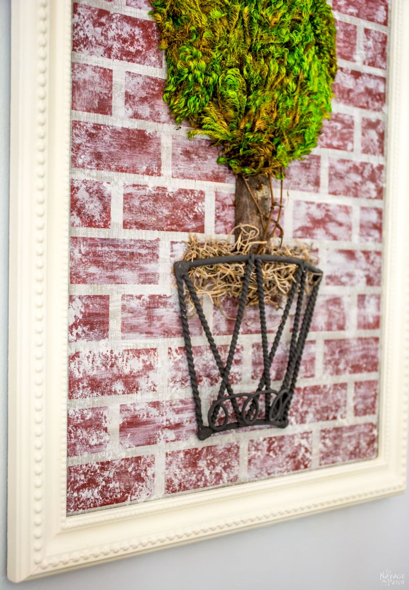 Topiary Wall Art | Joss & Main wall decor knock-off | DIY moss topiary wall decor | Upcycled metal basket | How to stencil | Homemade chalk paint recipe | How to fix a broken picture frame and make it look new | Creating a brick look with diy chalk paint | DIY 3D moss topiary wall art | Cheap & easy crafts | Simple DIY home decor | Evergreen wall decor | TheNavagePatch.com