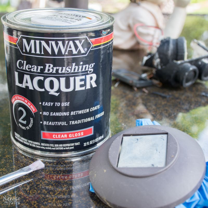 can of lacquer next to a landscape light with a hazy solar panel