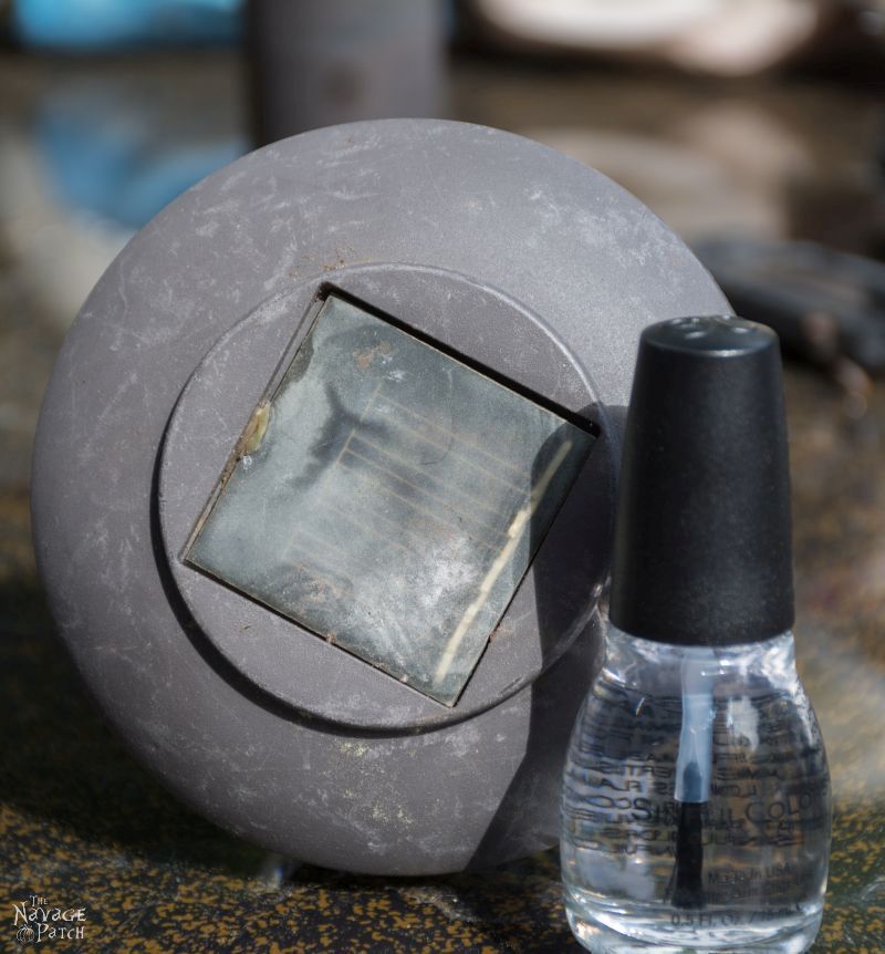 bottle of clear nail polish next to a hazy solar panel