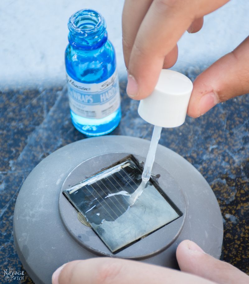 brush applying clear nail polish to a hazy solar panel