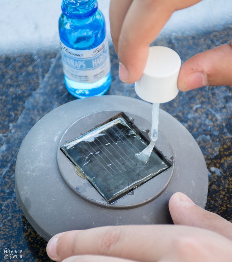 brush applying clear nail polish to a hazy solar panel