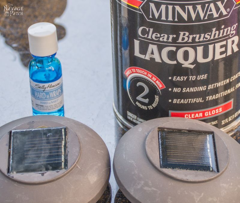 can of lacquer and bottle of clear nail polish behind to solar panels