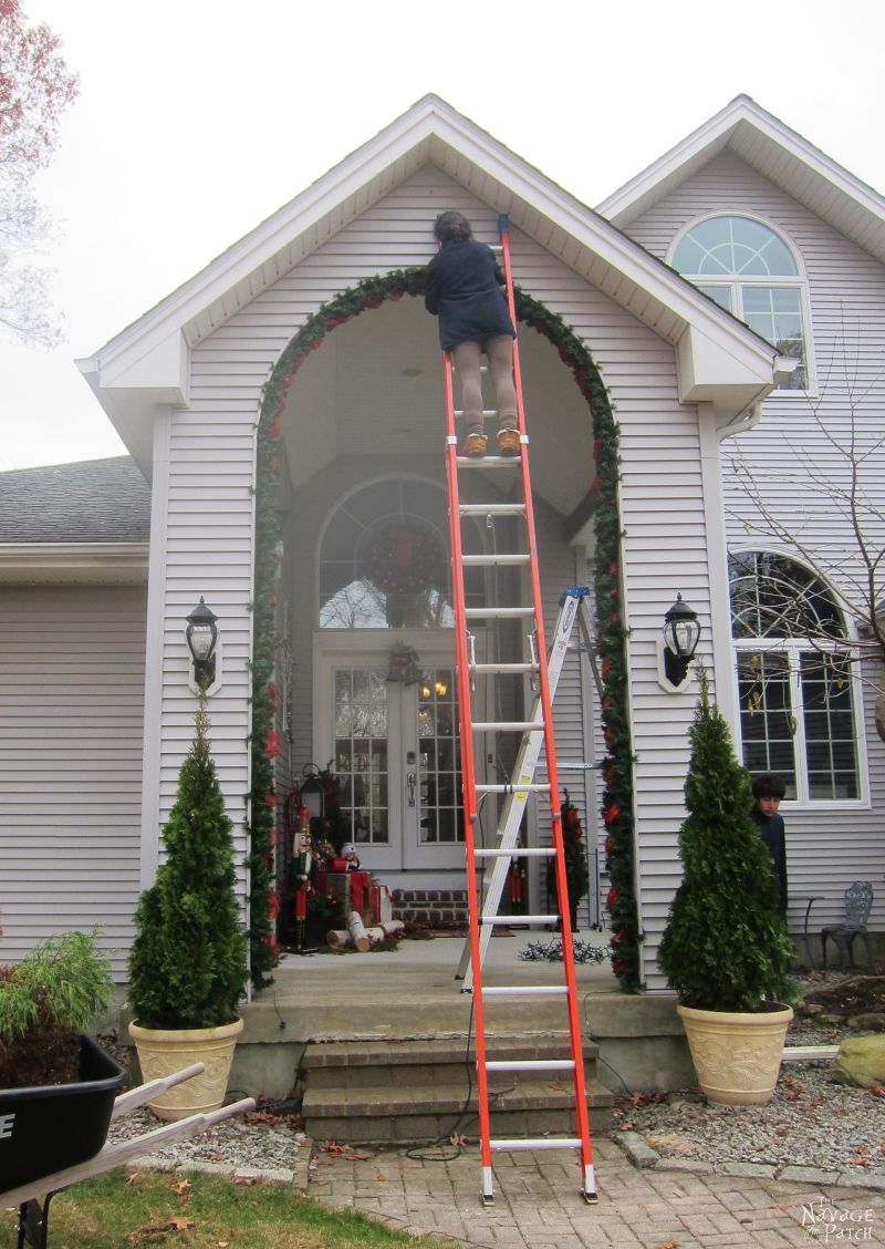 woman hanging diy outdoor christmas garland