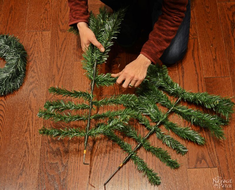 woman bending faux christmas tree branches