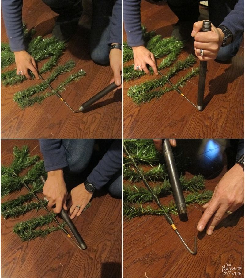 woman bending faux christmas tree branch stem with a pipe