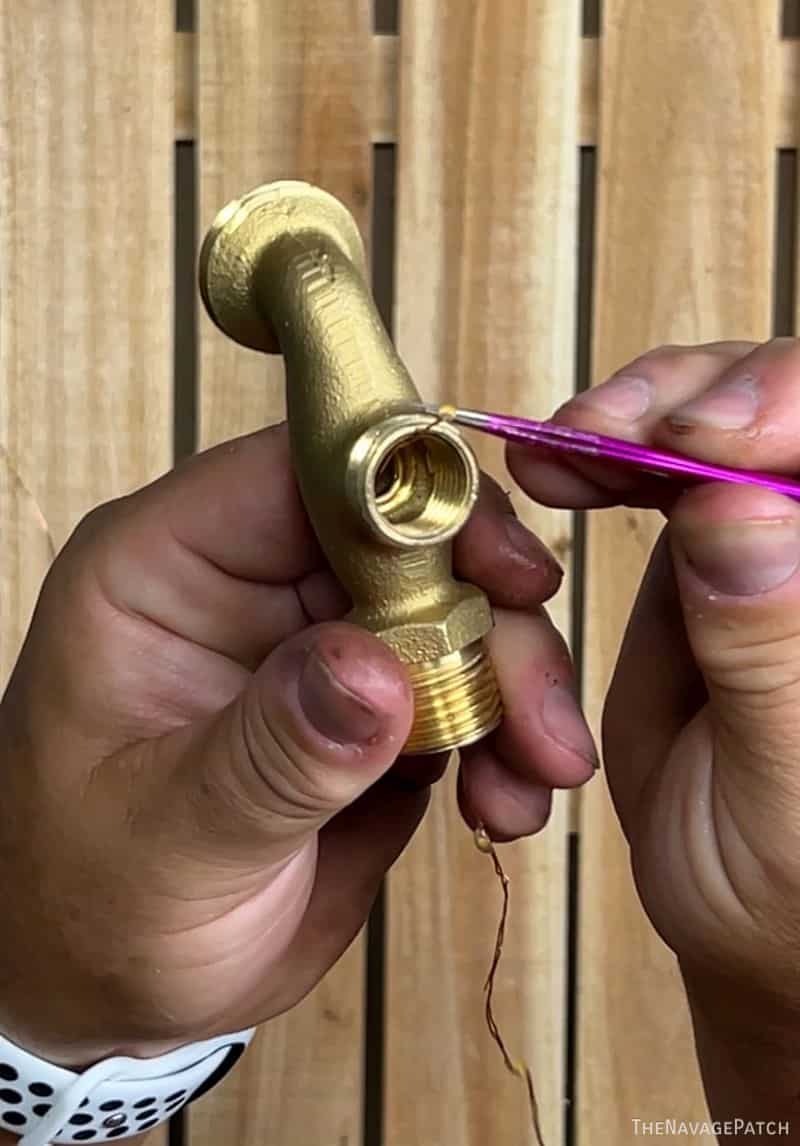 man feeding wire through spigot