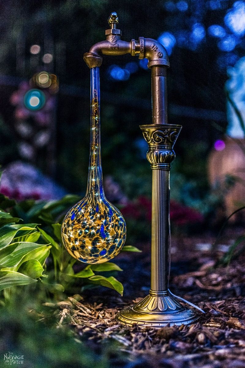 side view of a waterdrop solar light in a garden at dusk