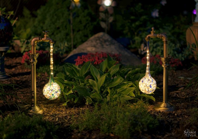 side view of two solar garden lights in a garden at night