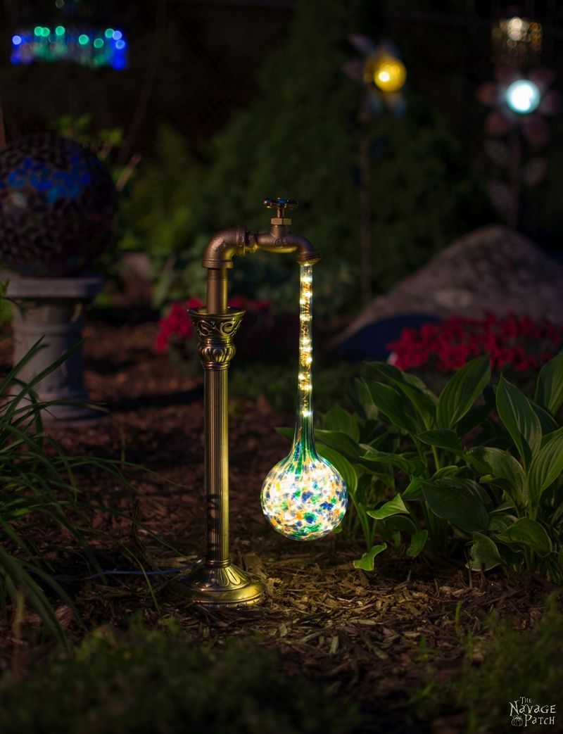 side view of solar garden light at night next to a hosta