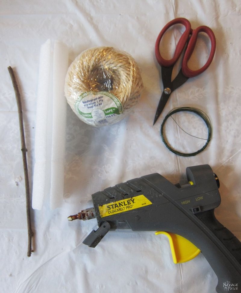 twine, scissors, glue gun, stick and wire on a table