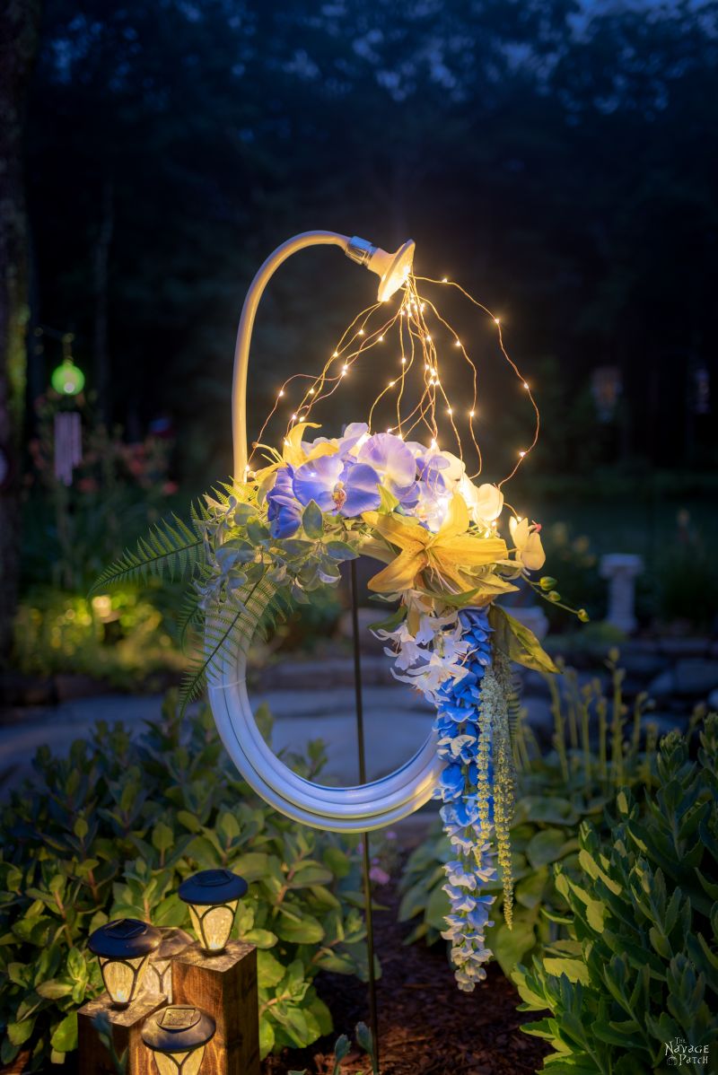 Lighted Garden Hose Wreath | DIY lighted summer wreath | Garden hose watering lights | Repurposed garden shed decor | Upcycled backyard decor | Summer wreath with fairy lights | #TheNavagePatch #GardenShed #garden #DIY #gardendecor #Upcycled #Repurposed #summerwreath #gardenart #diycrafts #Porchdecor #backyard #easydiy #outdoors #summerlife | TheNavagePatch.com