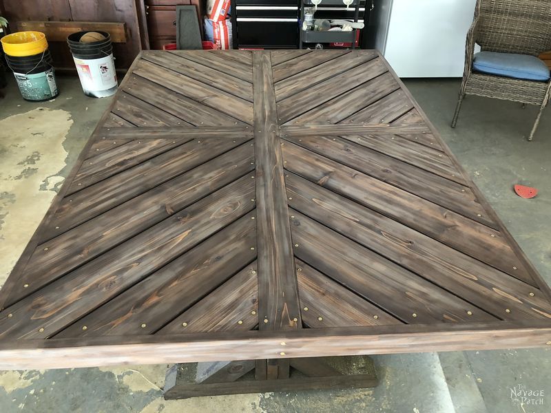 DIY farmhouse table with herringbone table top | DIY trestle table with free plans| How to make a herringbone table top | How to get the weathered wood look with stain | How to build an outdoor dining table | DIY dining table with free plans | How to get the aged wood look with stain | #TheNavagePatch #diy #farmhouse #HowTo #diyfurniture #freeplans #myrustoleum | TheNavagePatch.com