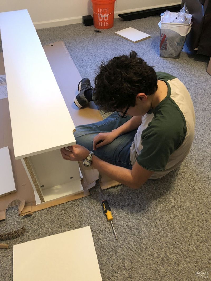 boy building an Ikea Billy bookcase