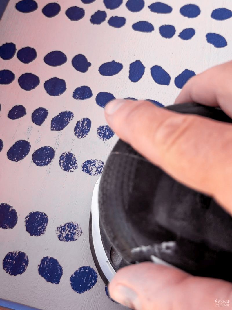 man sanding a old paint from a guitar display case