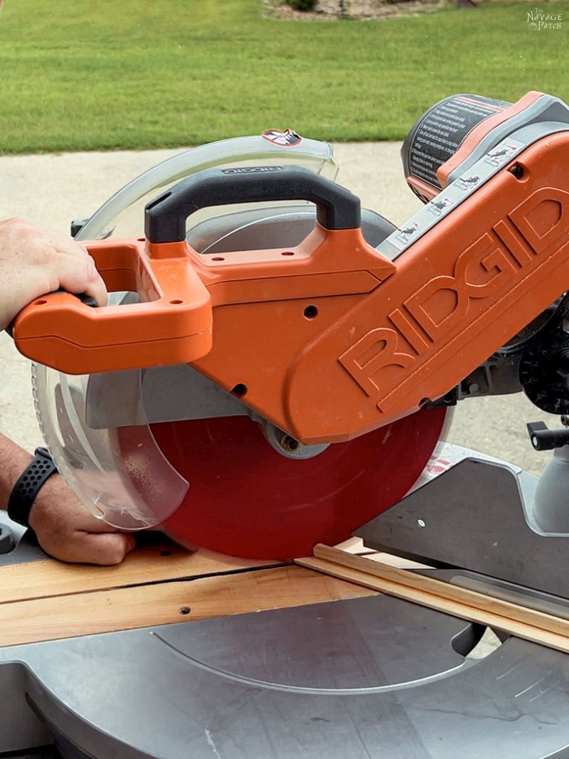 man cutting moulding with a miter saw