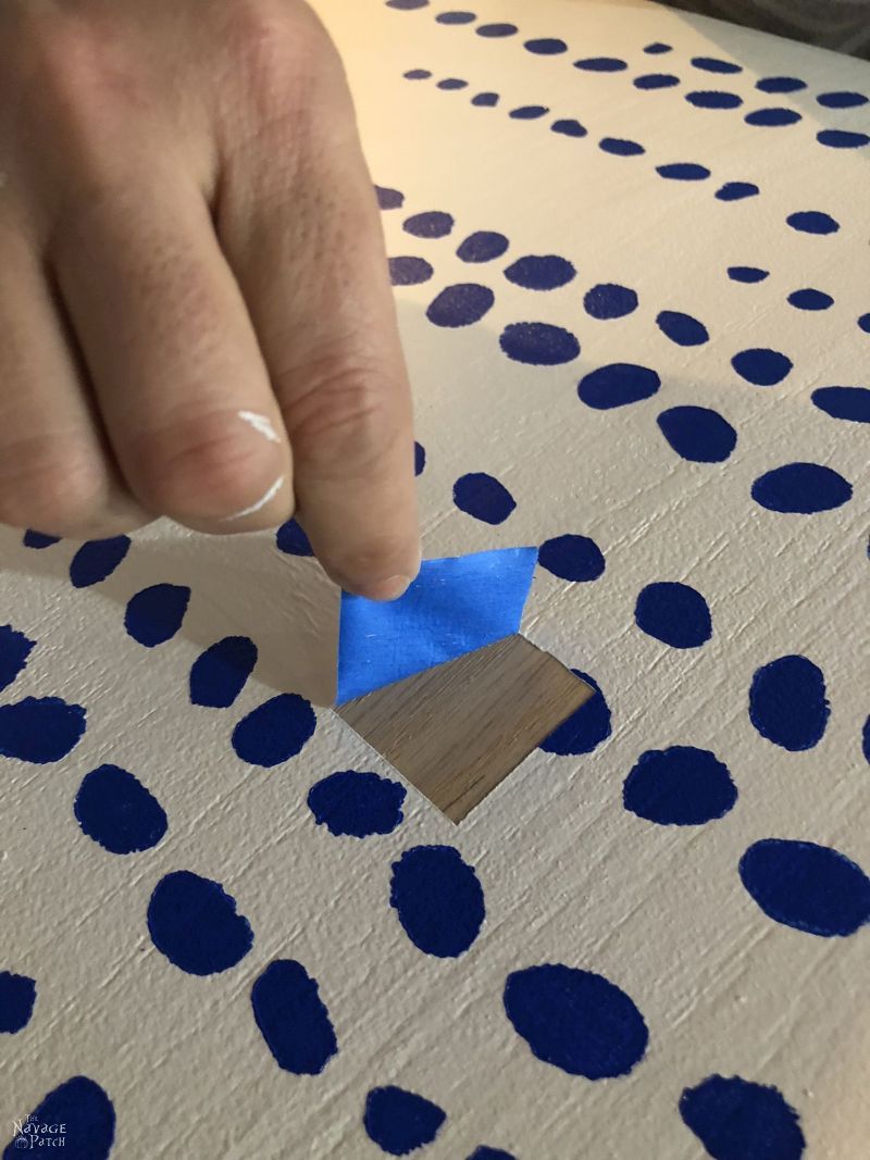 peeling masking tape from a painted surface