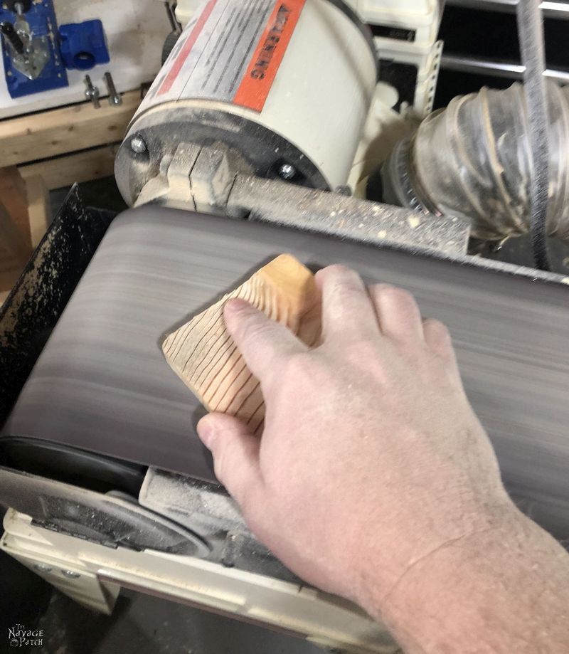 sanding a pine slice with a belt sander