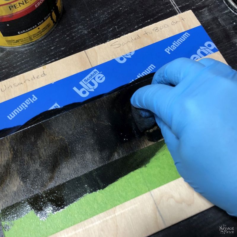 hand applying stain to plywood