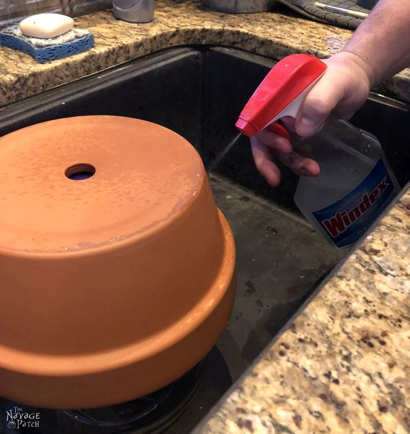 spraying a terra cotta pot with brine