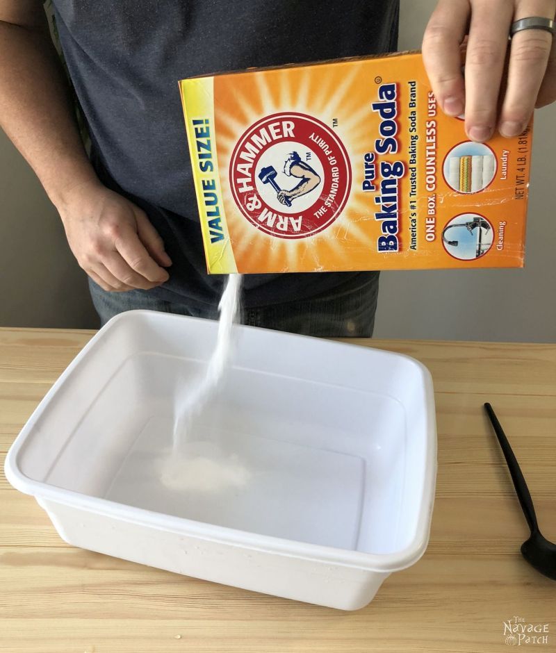 man pouring baking soda into a plastic tub