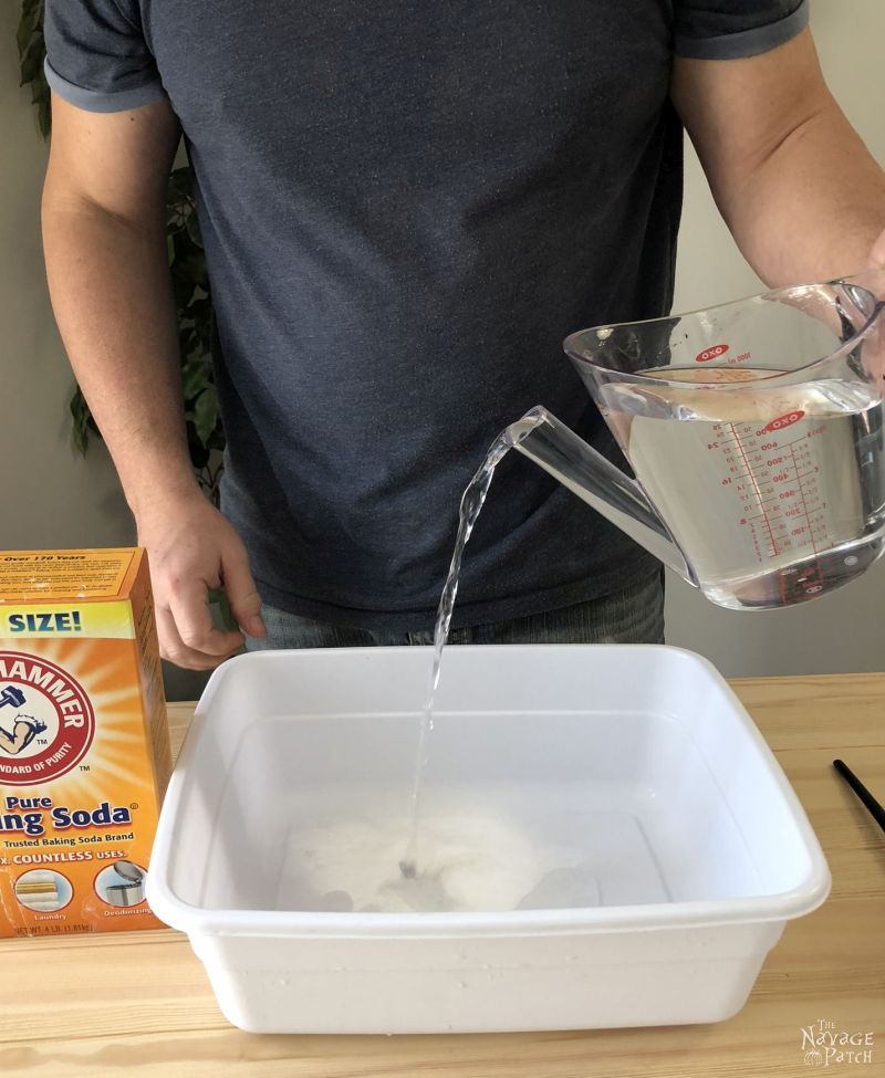 man pouring water into a plastic tub