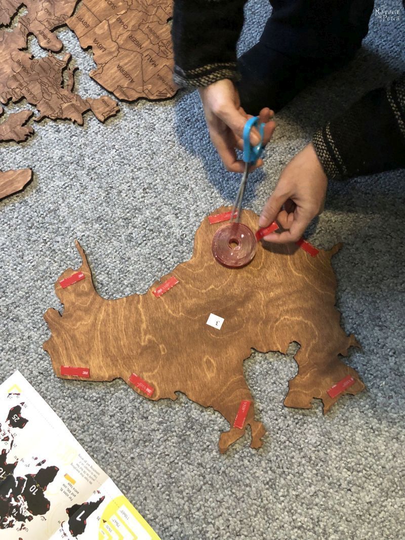 woman putting tape on wooden countries