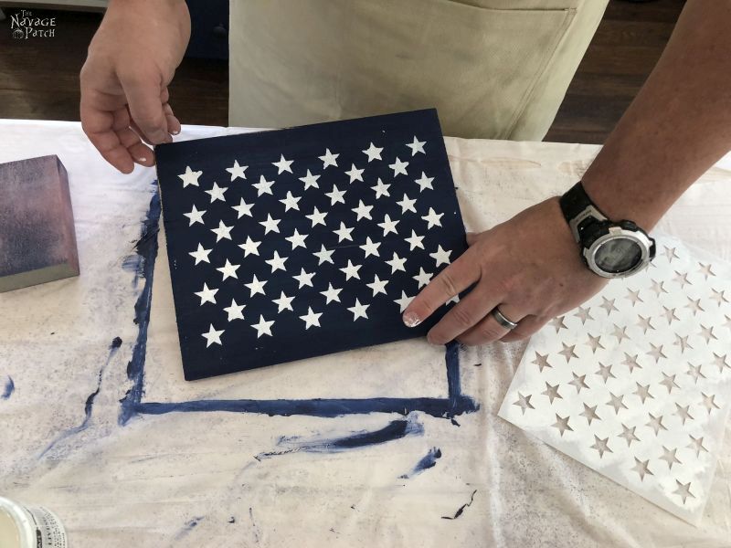 50 white stars stenciled on a blue painted piece of wood