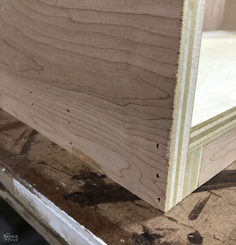 closeup of brad nail holes in the side of a diy laundry hamper