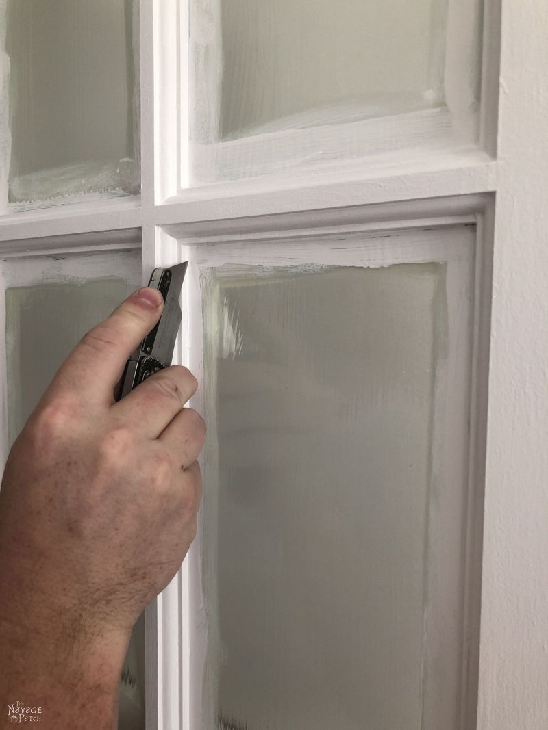 utility knife scoring along a glass pane