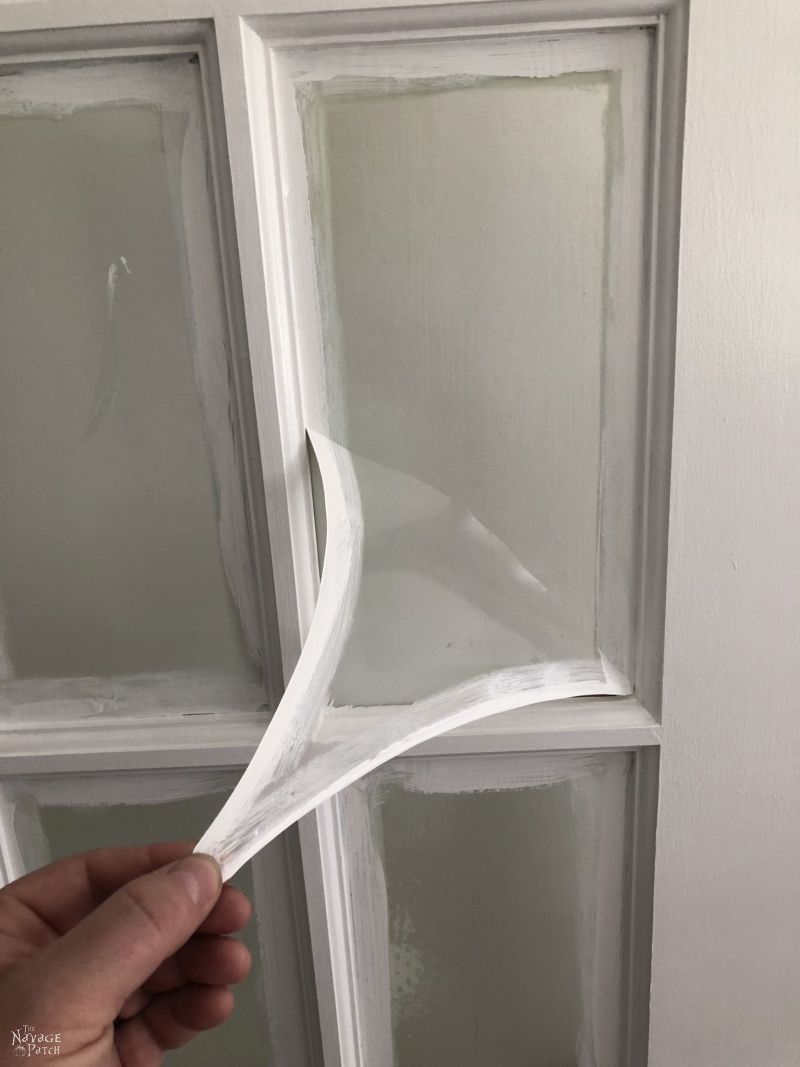 peeling the mask from a glass door panel