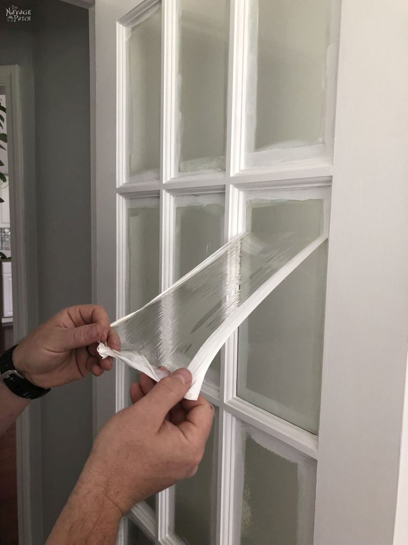 peeling the mask from a glass door panel