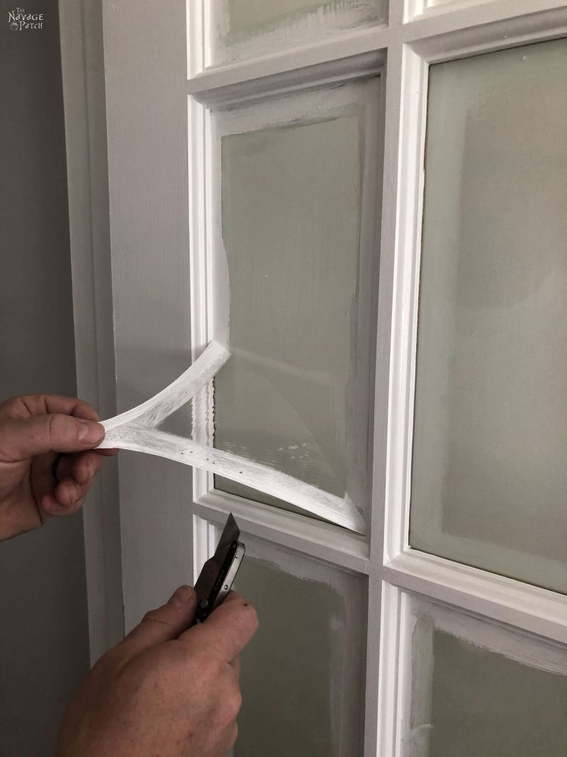 peeling the mask from a french door pane