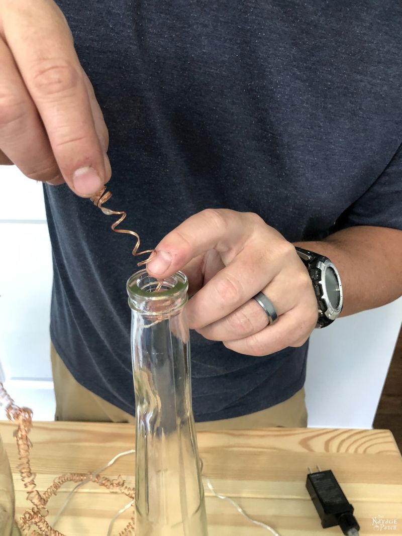 inserting fairy lights into a bottle