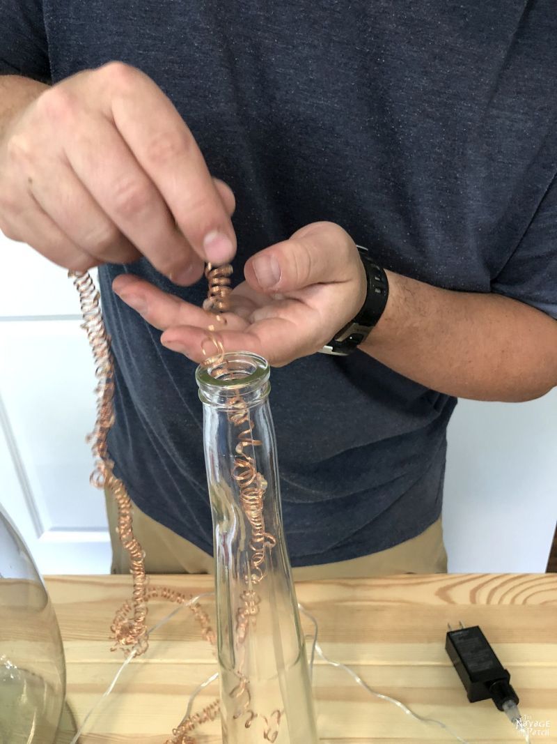 inserting fairy lights into a bottle