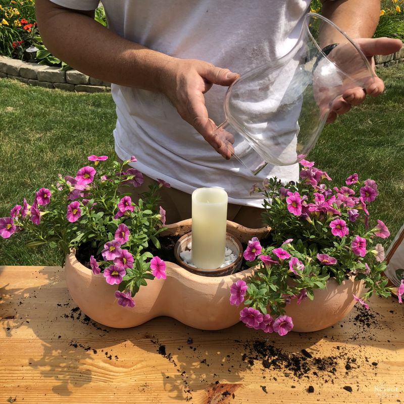 putting a candle into a clay pot planter