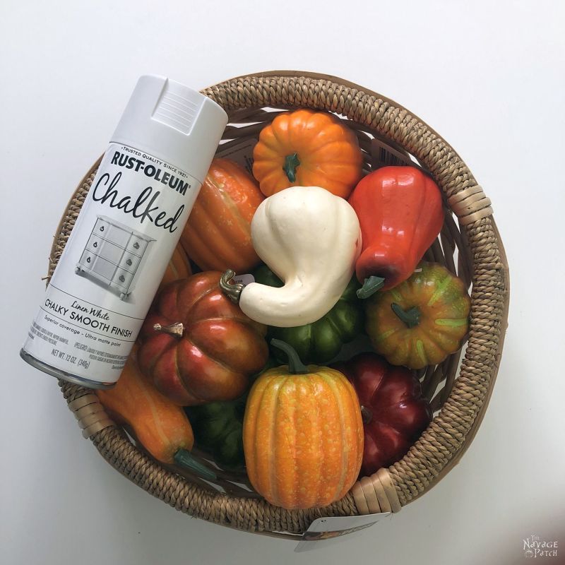 basket of dollar store pumpkins and white chalk spray paint