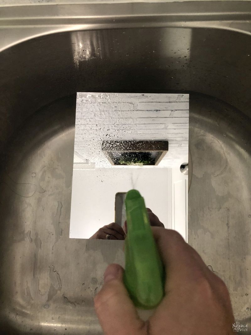 spraying bleach on a mirror