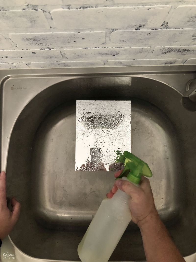 spraying bleach on a mirror