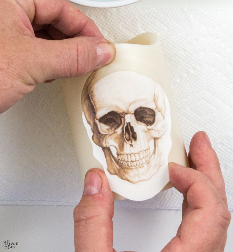 applying a waterslide decal to a DIY halloween candle
