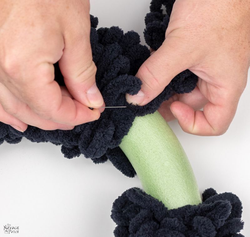 pinning loop yarn onto a wreath form for a spider wreath