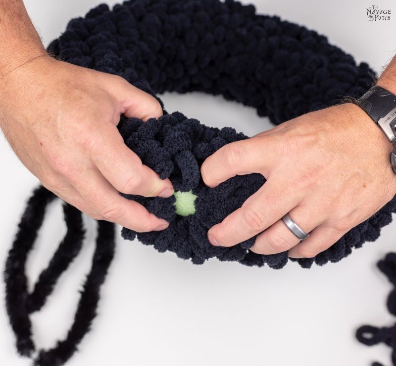 attaching chenille stems to a wreath form to make a spider wreath