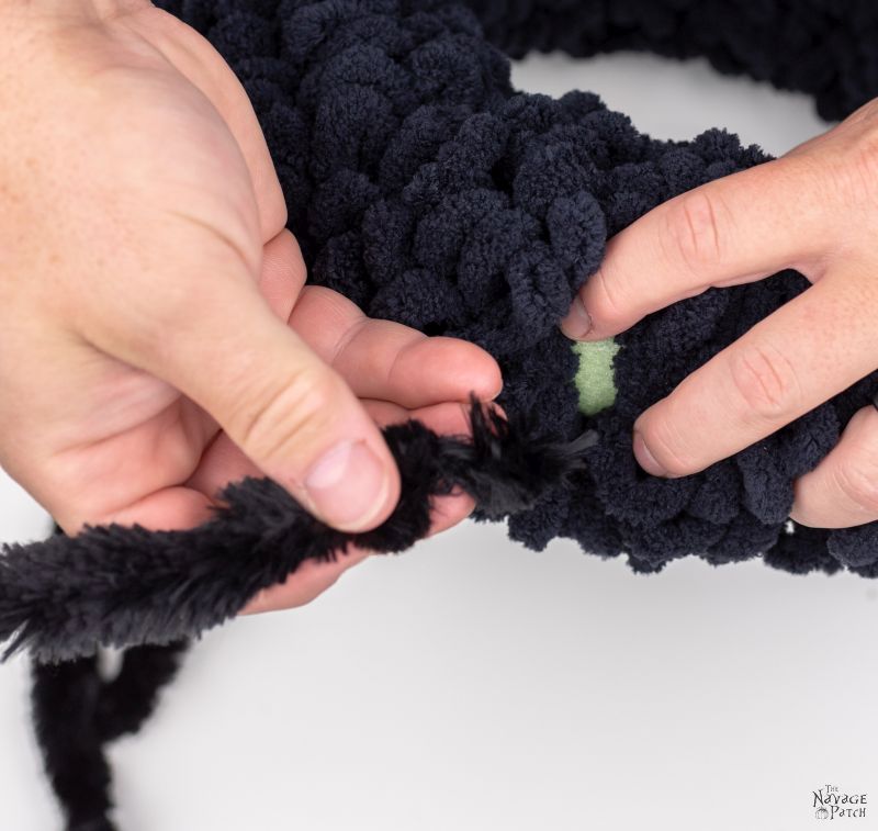 attaching chenille stems to a wreath form to make a spider wreath