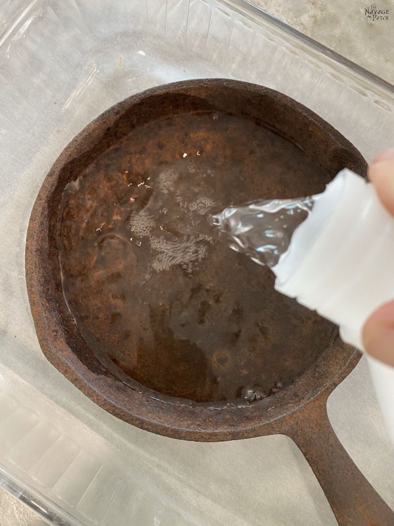 pouring vinegar on a cast iron pan