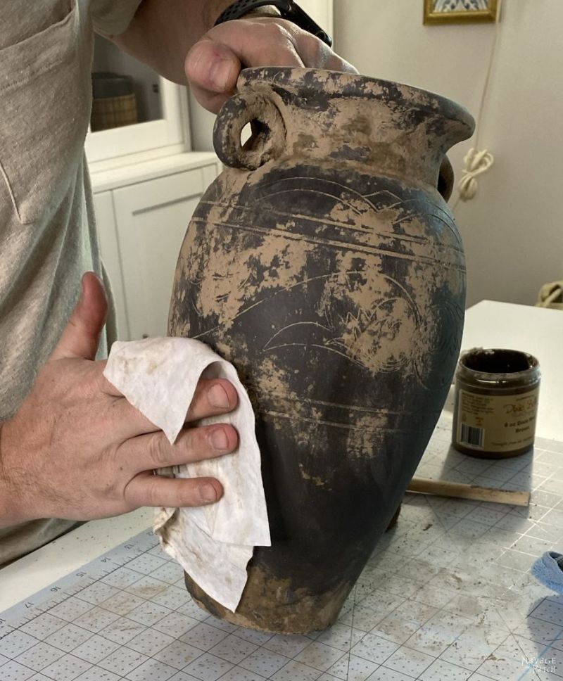 wiping mud paint from a vase