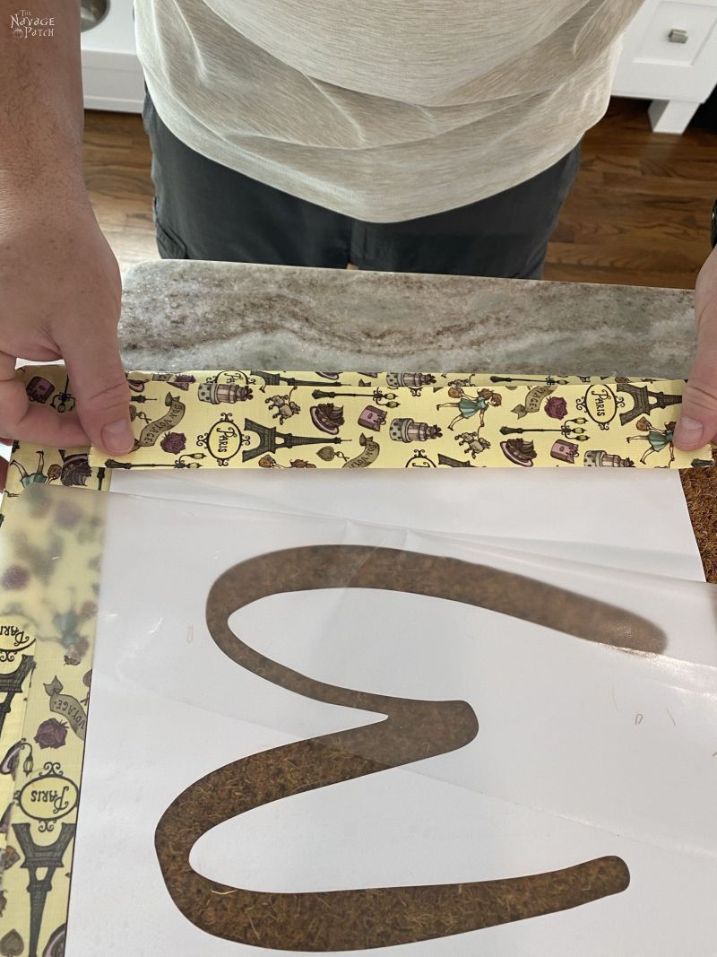 placing a stencil on a door mat