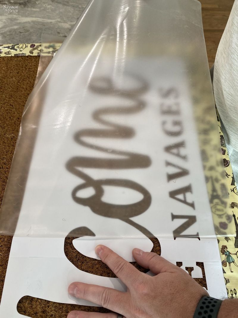 placing a stencil on a door mat