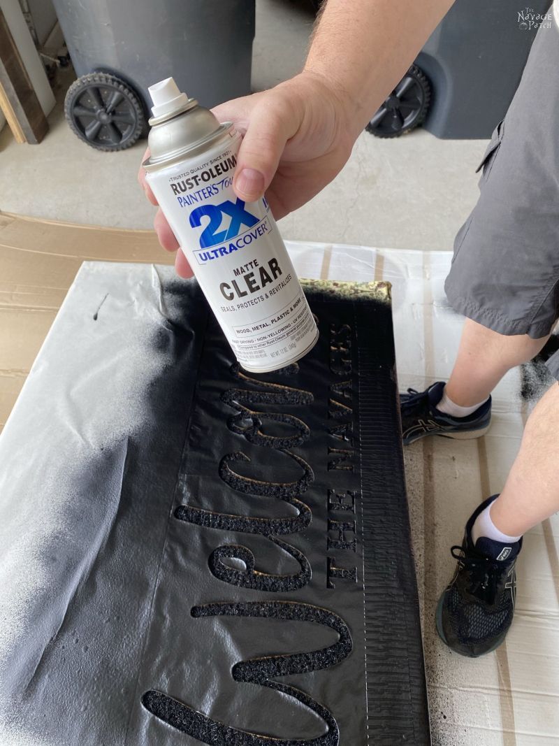 spraying a personalized door mat with sealant