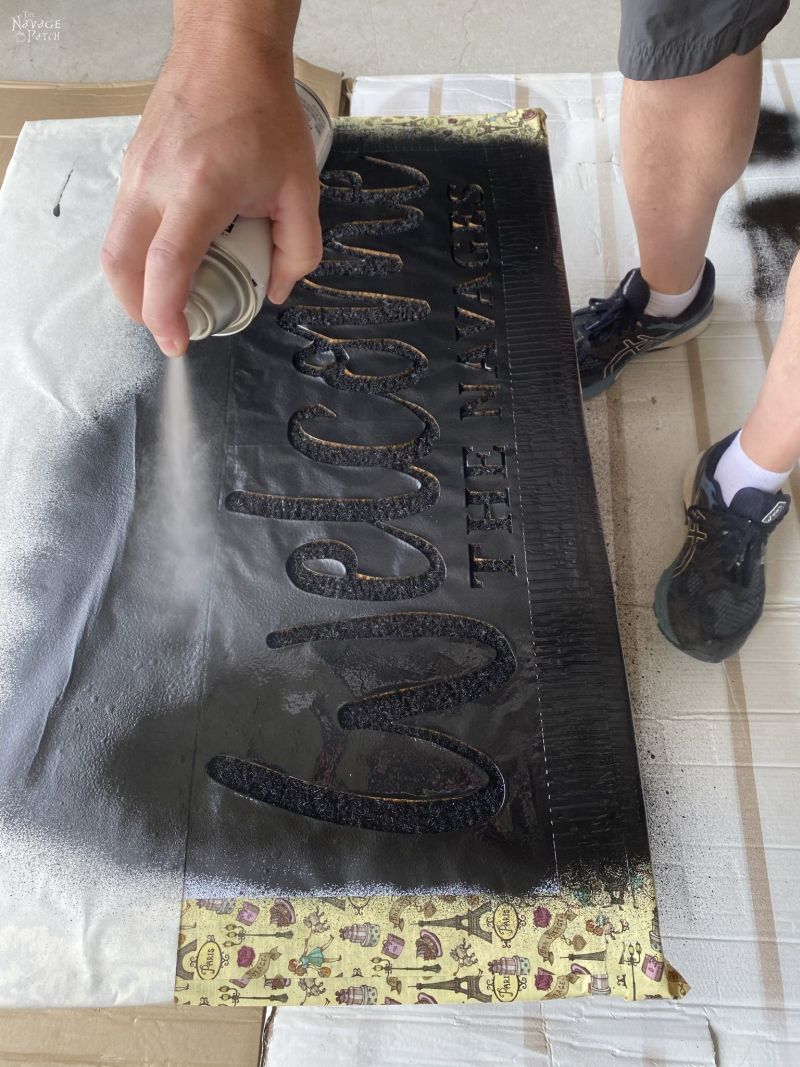 spraying a personalized door mat with sealant