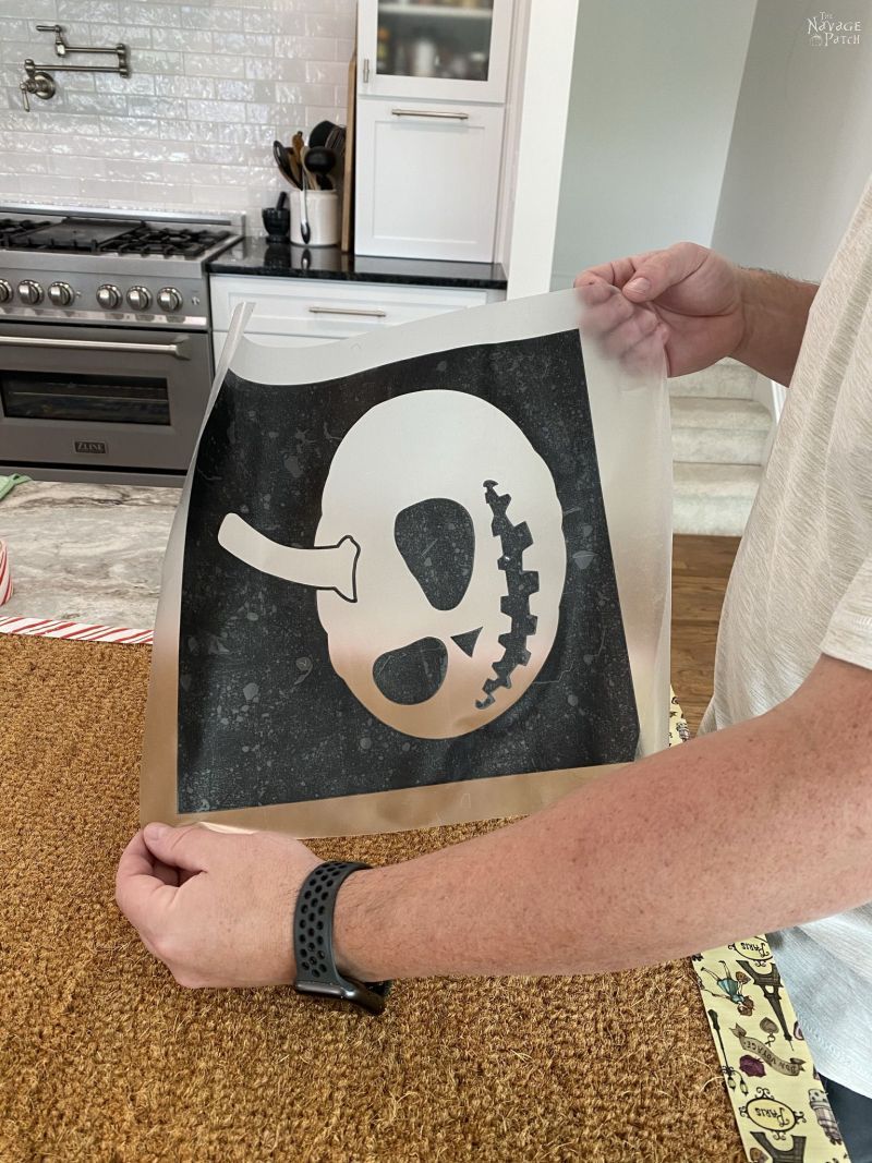 putting pumpkin stencils on a doormat