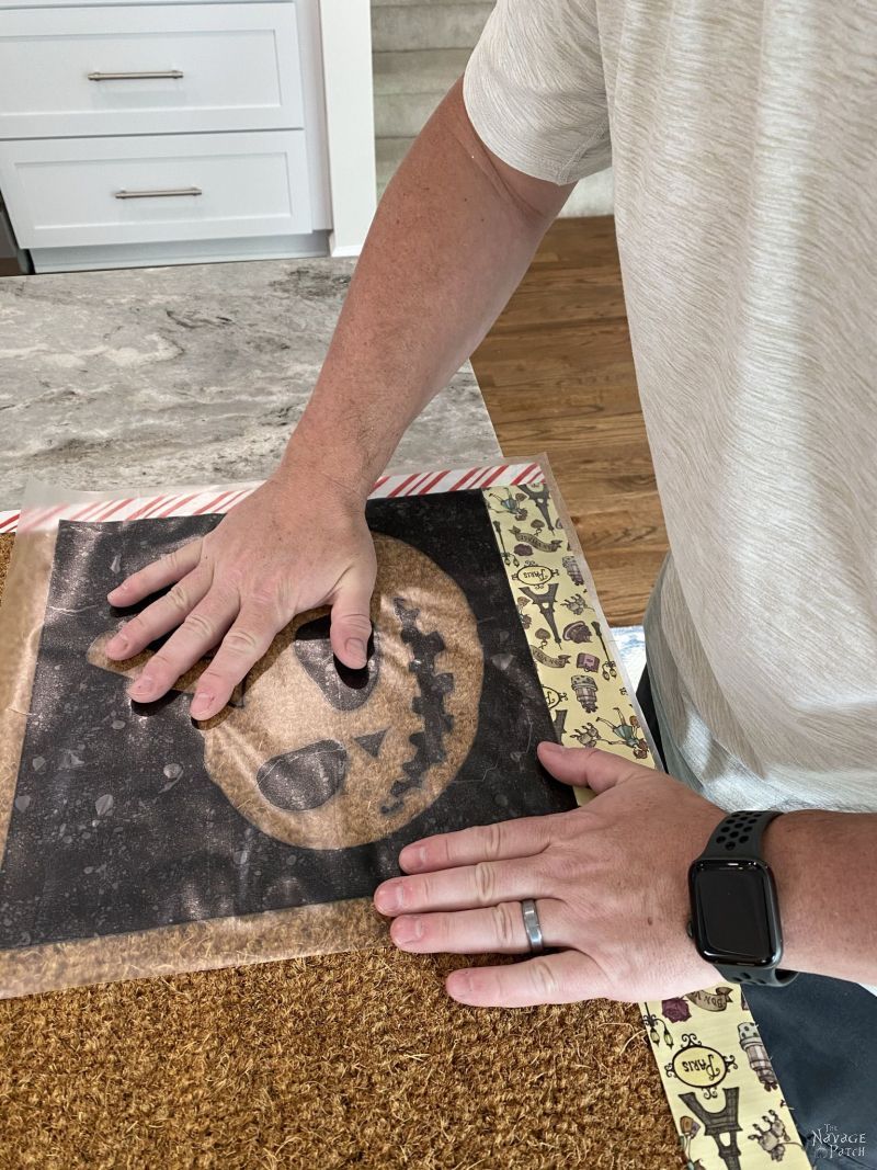 putting pumpkin stencils on a doormat